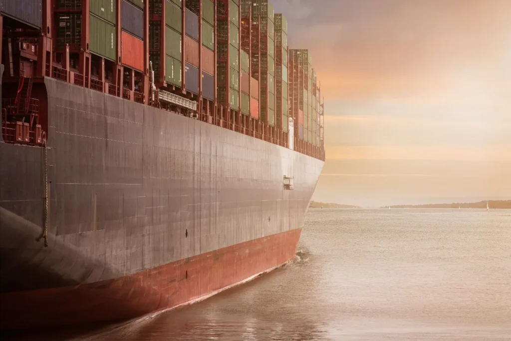 The bow of a laden container ship under way in evening light