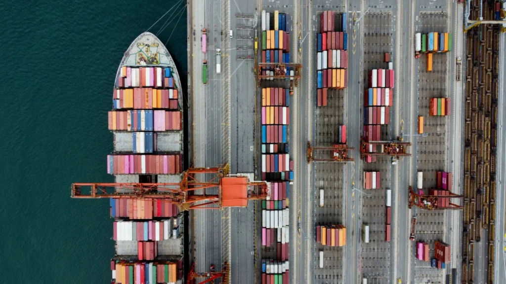 A container ship being worked alongside a container terminal, seen from above