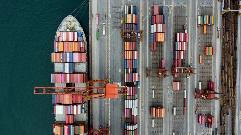 A container ship being worked alongside a container terminal, seen from above